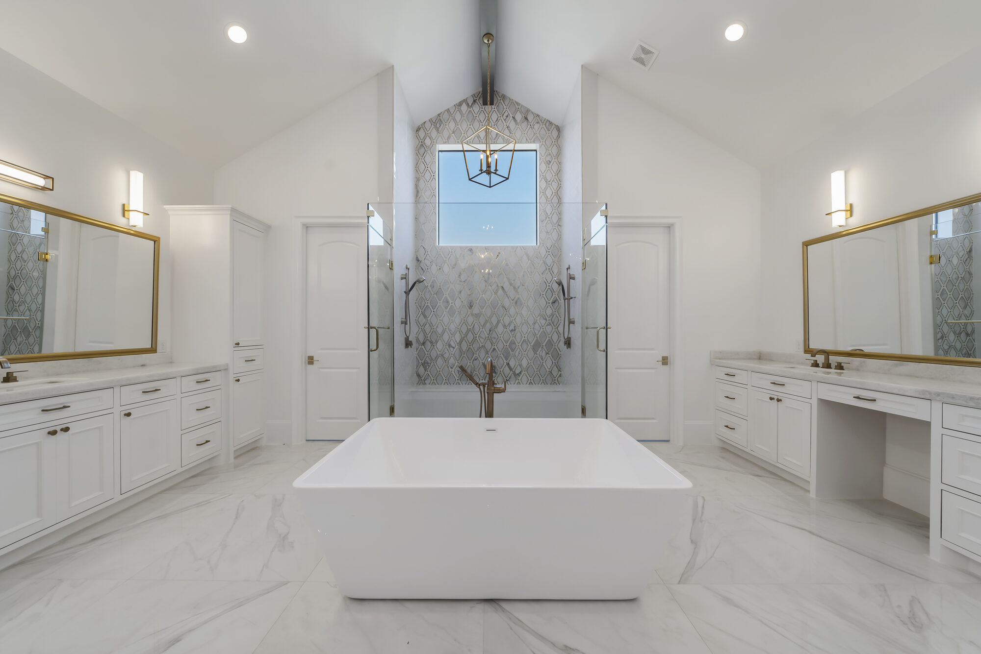 Spa-like primary bath with a freestanding soaking tub, twin vanities, and a mosaic-tiled wet room