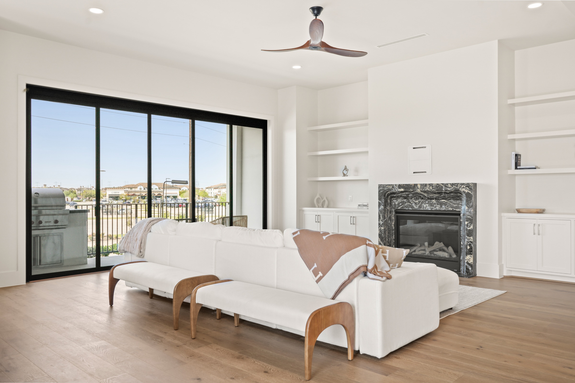 Living room with a marbled fireplace and sliding glass to the balcony
