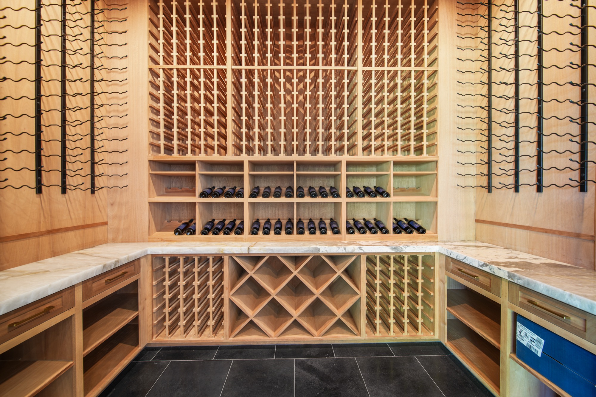 Wine cellar with iron-frame racks and custom millwork