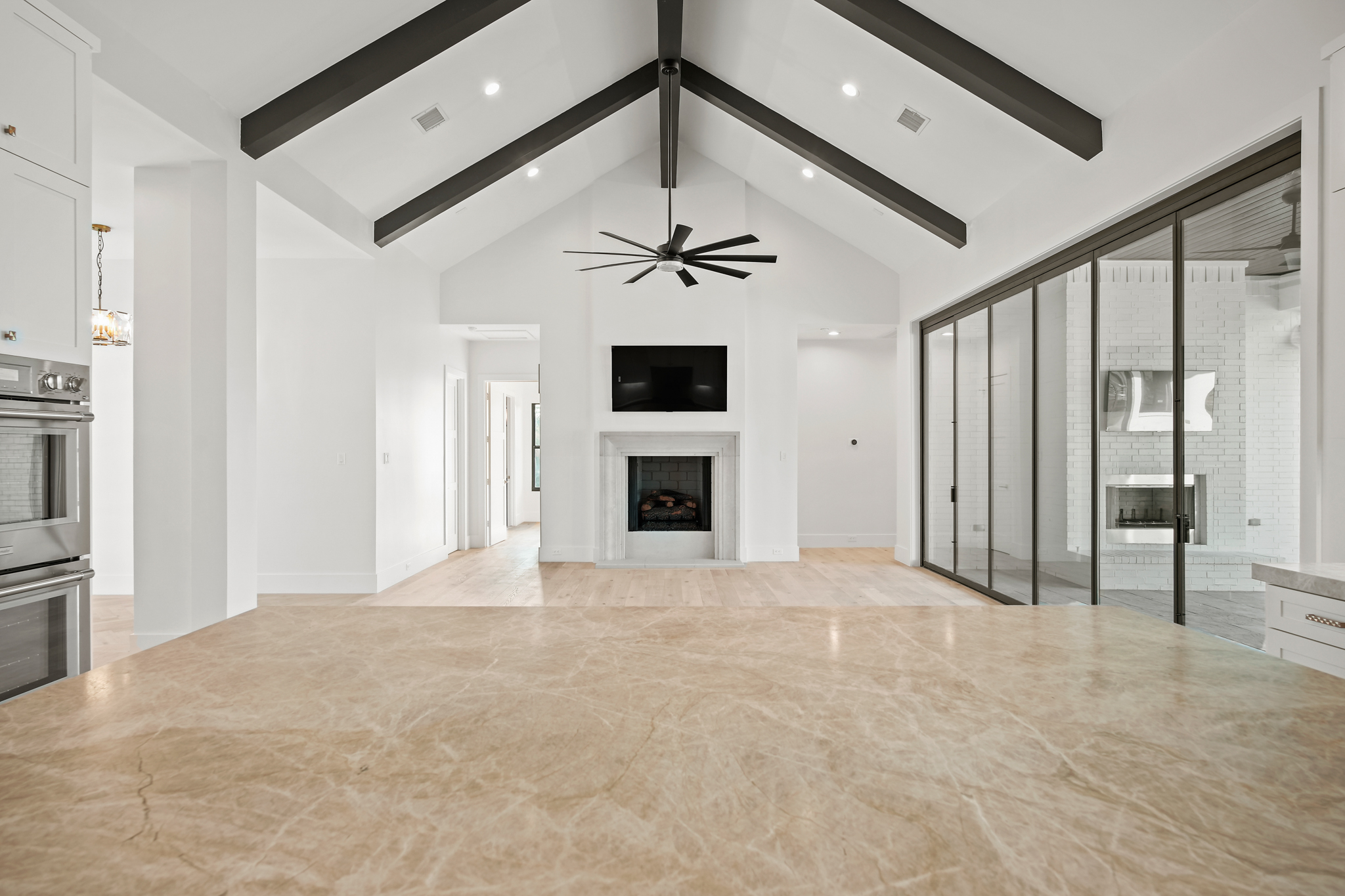 Living room with vaulted beamed ceiling and fireplace in a Psalms Fine Homes residence